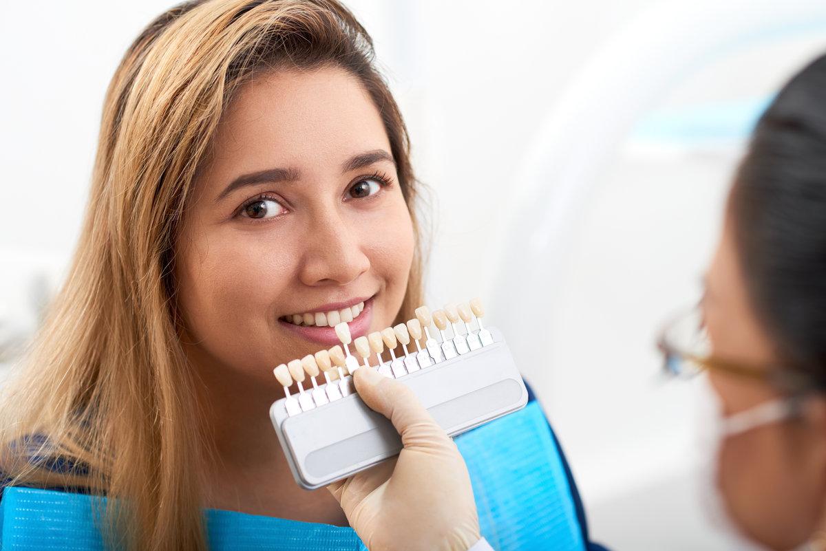 Young woman visiting doctor for teeth whitening Pretty smiling young Asian woman having teeth whitening procedure