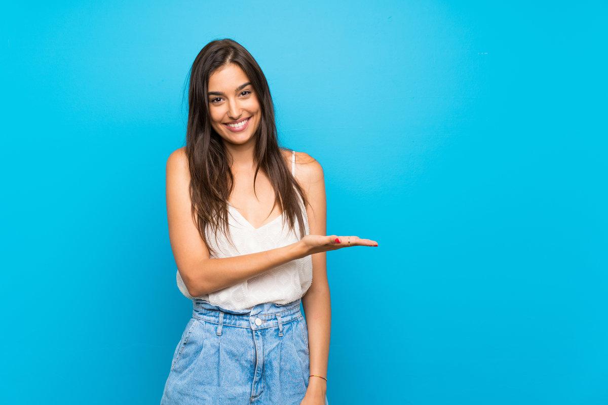 Young woman over isolated blue background smiling with a happy and pleasant expression Young woman over isolated blue background smiling with a happy and pleasant expression