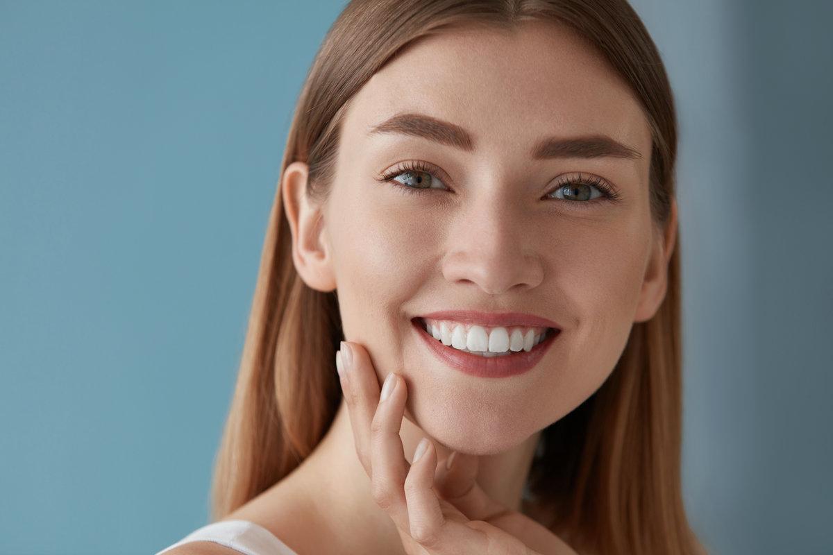 Beauty portrait of smiling woman with white teeth smile Beauty portrait of smiling woman with white teeth smile. Beautiful happy girl with fresh skin, natural face makeup indoors closeup