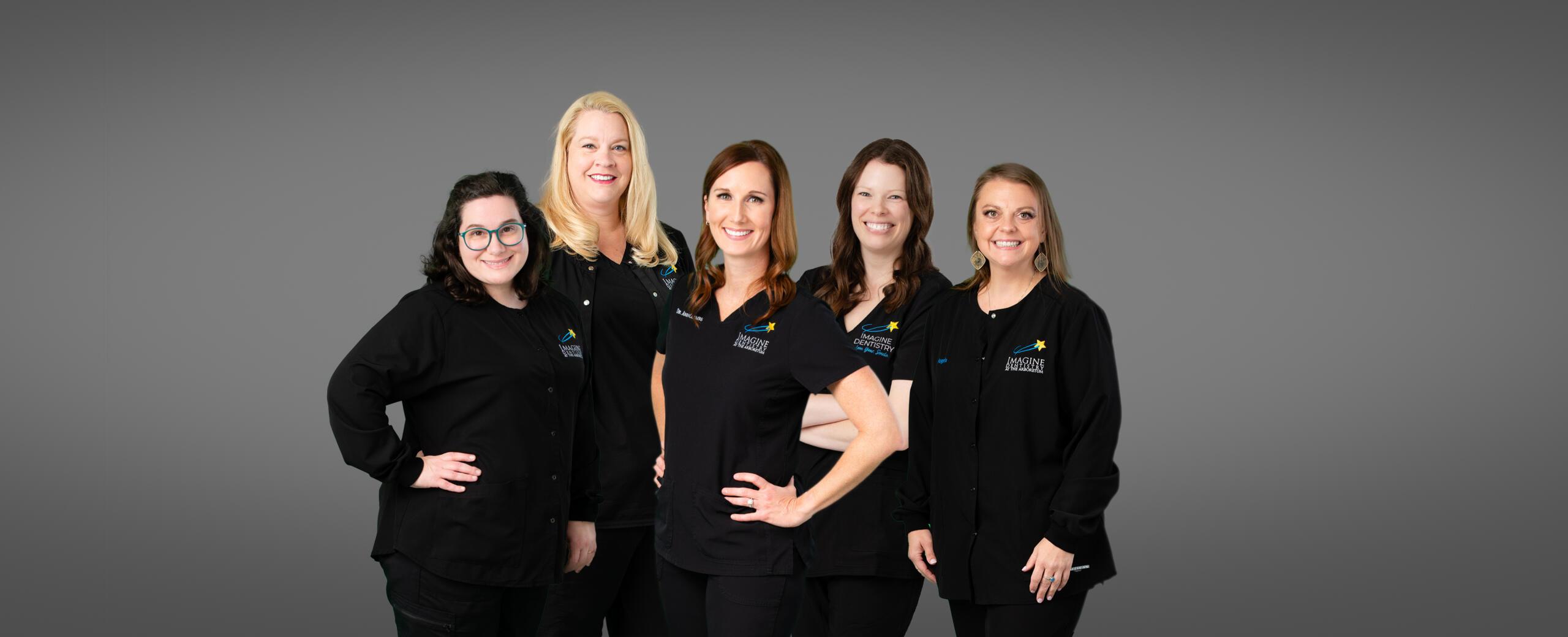 Imagine Dentistry team of five staff members in black uniforms